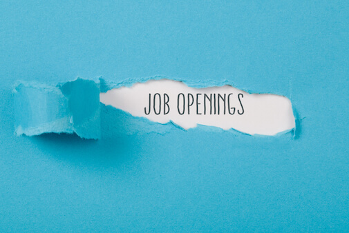 Job Openings message on torn blue paper revealing secret behind ripped opening.