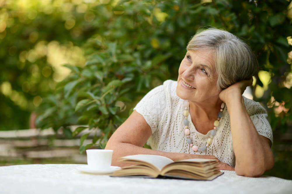 Older woman reading a book outside